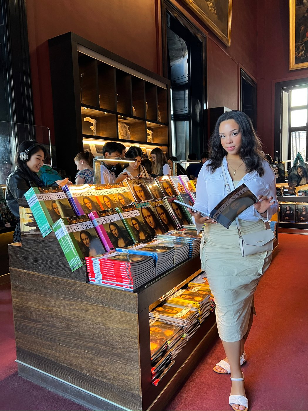 Delanna browsing a shelf of books in a wood-paneled reading room